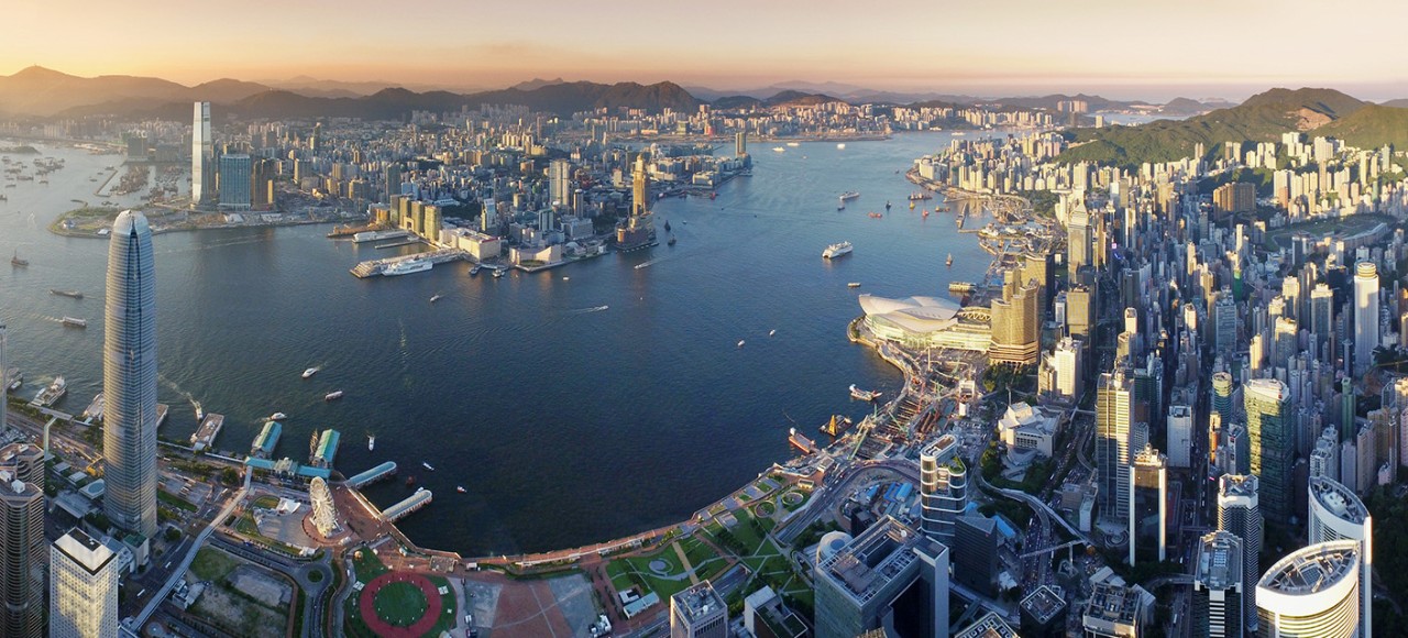 在沒有空氣污染的日子裡，在美麗的日落期間，香港島的壯麗天際線和繁忙的船隻駛過維多利亞港。